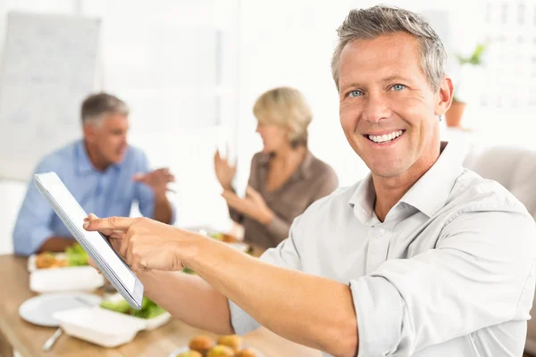 Businessman using tablet at lunch — Stock Photo, Image