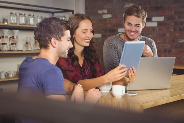 Smiling friends looking at tablet computer — Stock Photo, Image