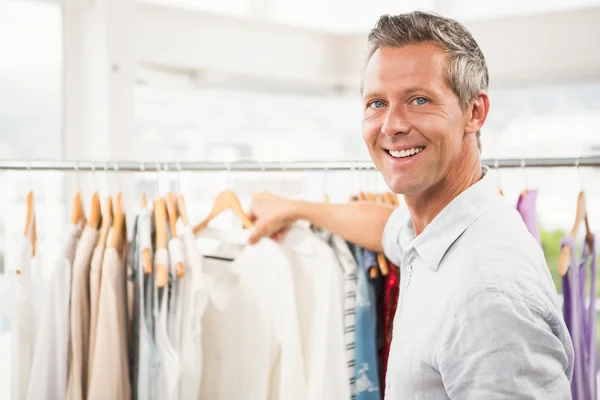 Sonriente hombre buscando ropa — Foto de Stock