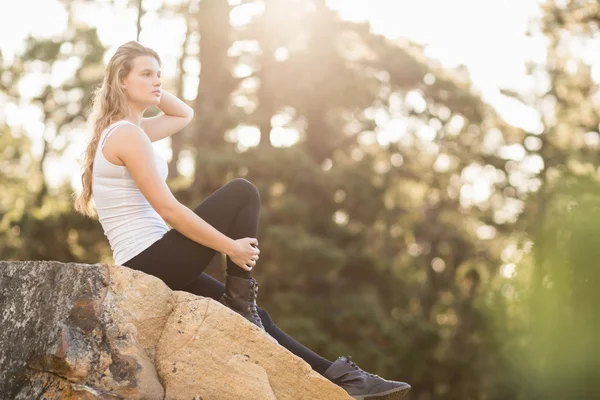 Jeune joggeuse assise sur le rocher — Photo