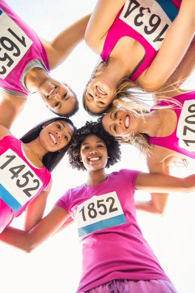 Пять улыбающихся бегунов, поддерживающих марафон рака груди — стоковое фото