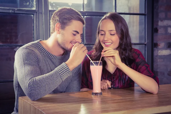 Amigos sorrindo compartilhar smoothie — Fotografia de Stock