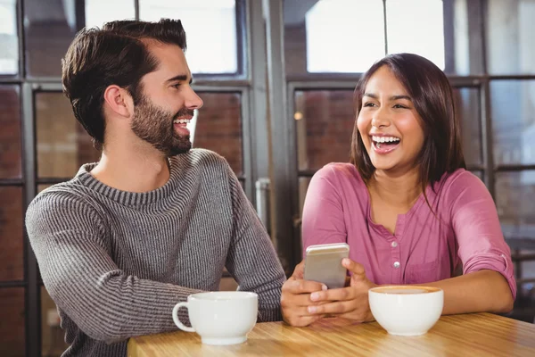 Linda pareja mirando un teléfono inteligente — Foto de Stock