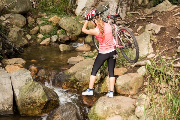 Athlete carrying her mountain bike — Stock Photo, Image