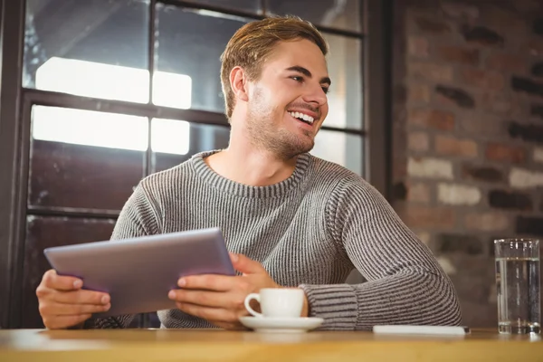 Mann lächelt und hält Tablet-Computer in der Hand — Stockfoto