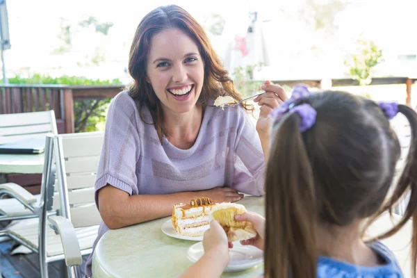 Moeder en dochter genietend van taarten — Stockfoto
