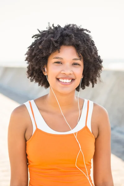 Vrouw genieten van muziek via hoofdtelefoon — Stockfoto