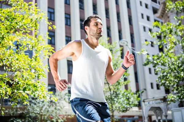 Спортсмен біжить перед будівлями — стокове фото