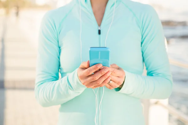 Ajuste mujer sosteniendo teléfono — Foto de Stock