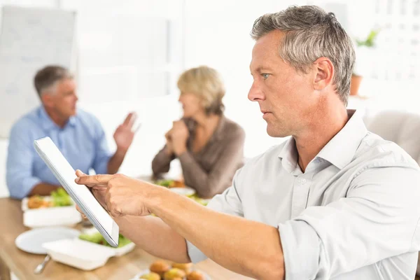 Zakenman met behulp van Tablet PC tijdens de lunch — Stockfoto