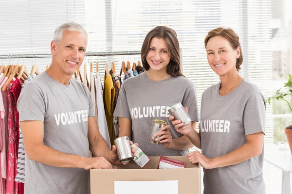 Lachende vrijwilligers sorteren donaties — Stockfoto