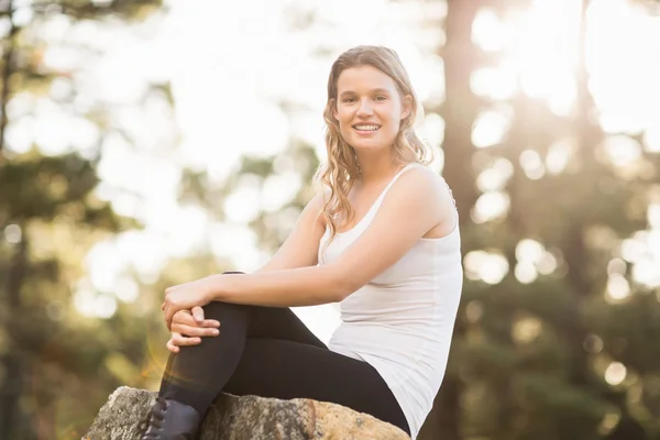 Junger glücklicher Jogger sitzt auf Felsen — Stockfoto