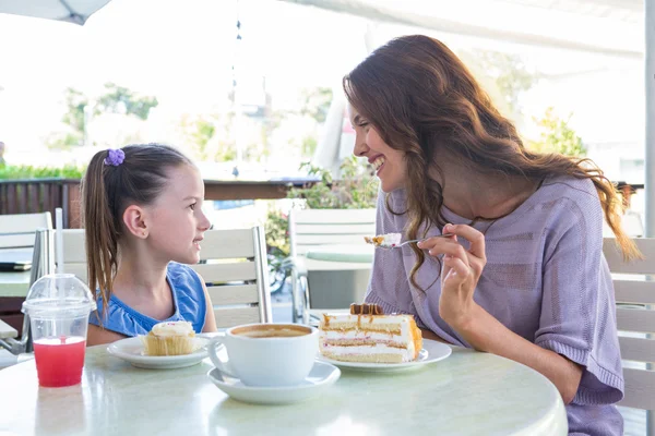 Mother and daughter enjoying cakes — Stock Photo, Image