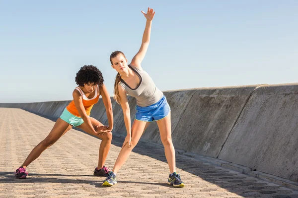 Two young woman stretching together — Stock Photo, Image