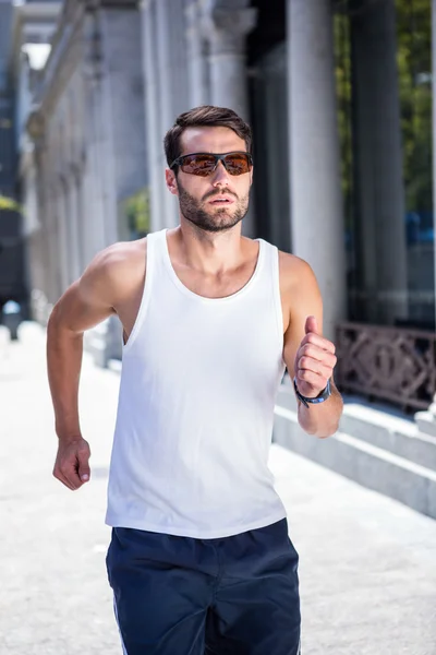 Athlete with sunglasses jogging — Stock Photo, Image
