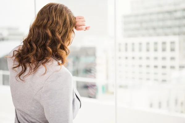 Businesswoman leaning against window — Stock Photo, Image