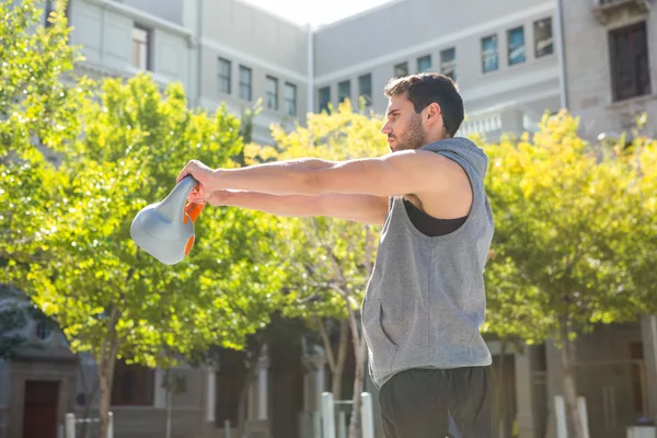 Athlete lifting kettle bell — Stock Photo, Image