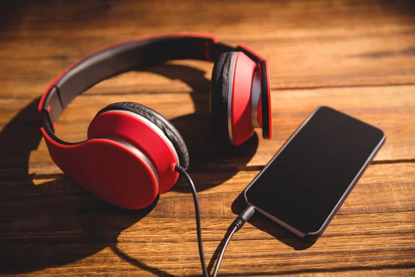 Desk with headphones and phone — Stock Photo, Image