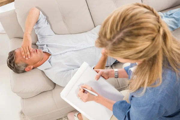 Депрессивный мужчина лежит на диване — стоковое фото