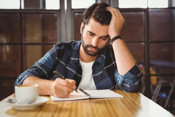 Homem tomando notas em seu caderno — Fotografia de Stock