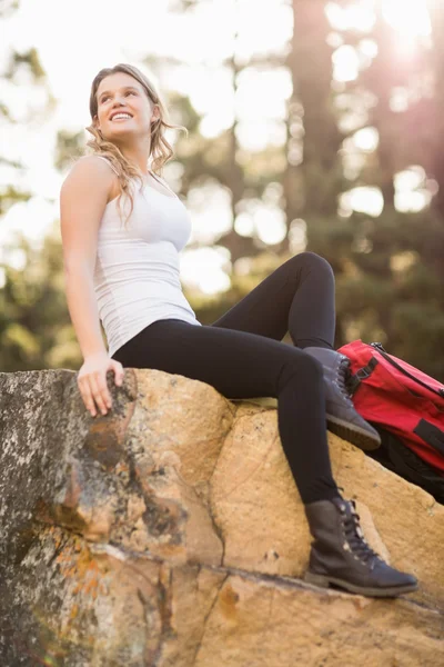 Jovem corredor feliz sentado no rock — Fotografia de Stock