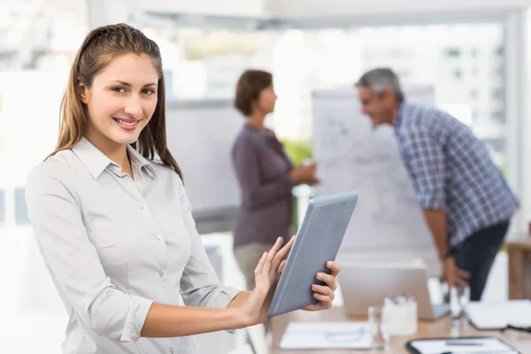 Glimlachende zakenvrouw met tablet in een vergadering — Stockfoto