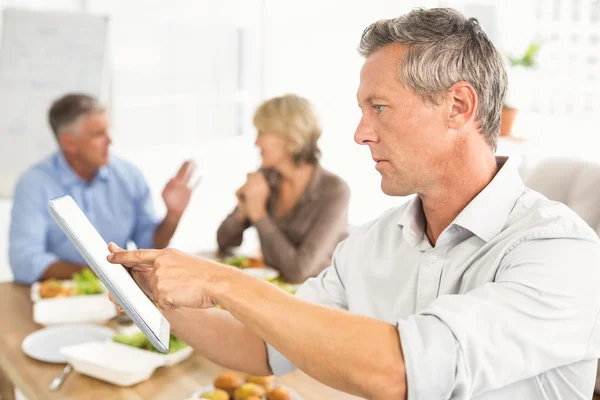 Businessman using tablet at lunch Stock Photo