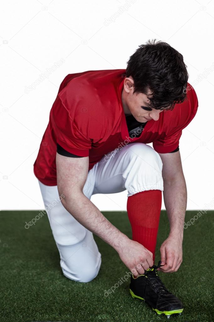 Football player tying his shoelaces Stock Photo by ©Wavebreakmedia 84465748
