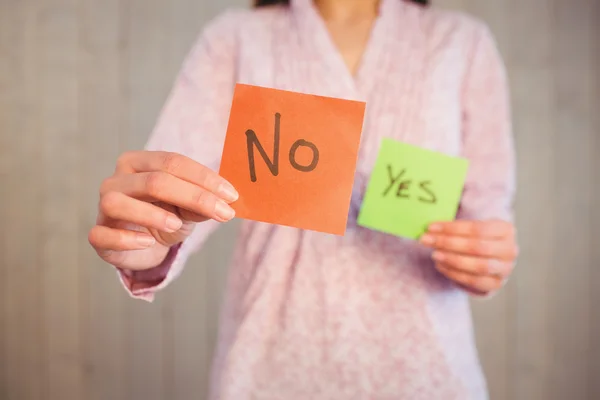 Mujer sosteniendo sí y no tarjetas — Foto de Stock