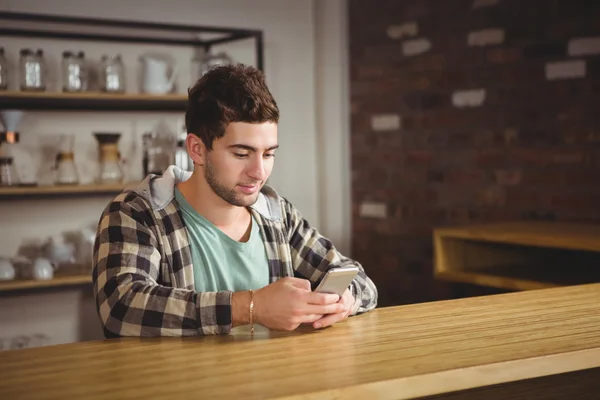 Leende hipster sitter och textning — Stockfoto