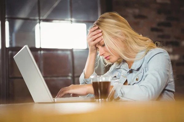 Blondin sitter och använder bärbar dator — Stockfoto