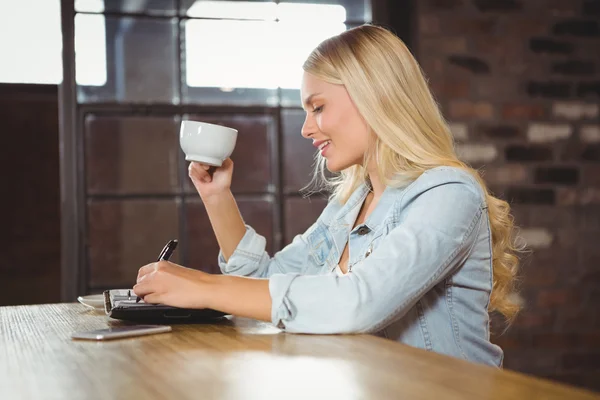 Улыбающаяся блондинка пьет кофе — стоковое фото