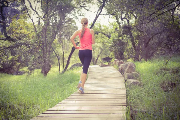 Sportler joggt auf Holzpfad — Stockfoto