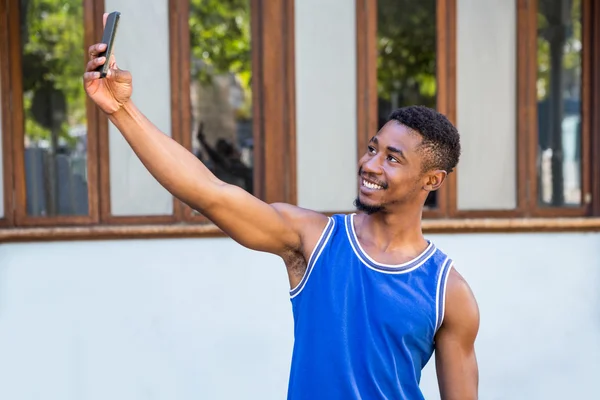 Przystojny sportowiec biorący selfie — Zdjęcie stockowe
