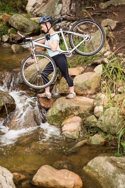 Femme soulevant son vélo — Photo