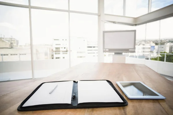 Tablet and planner in front of meeting room