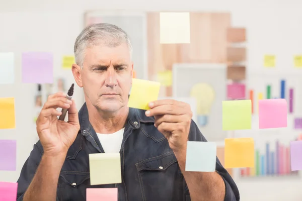 Businessman writing on post its — Stock Photo, Image