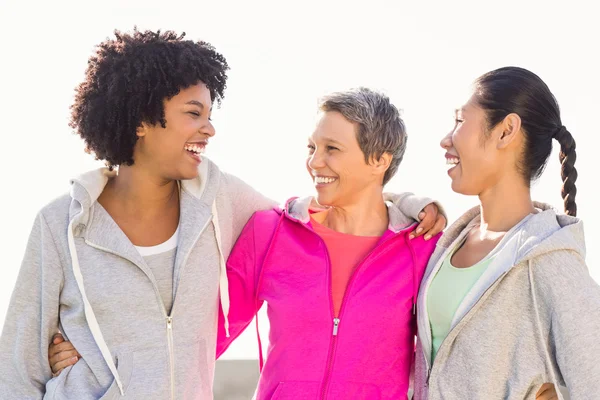 Lachende sportliche Frauen mit herumliegenden Armen — Stockfoto