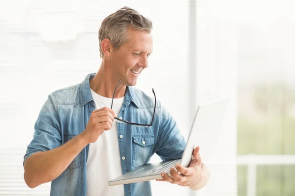 Empresario sosteniendo un portátil — Foto de Stock