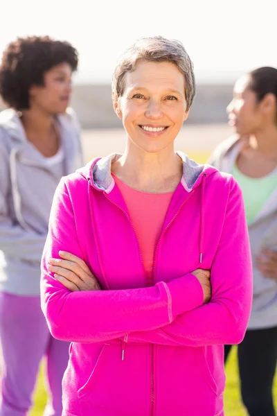 Woman with arms crossed in front of friends — Stock Photo, Image