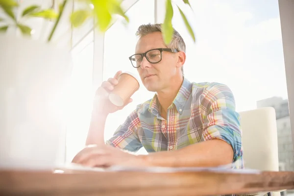 Designer drinking out of take-away cup — Stock Photo, Image