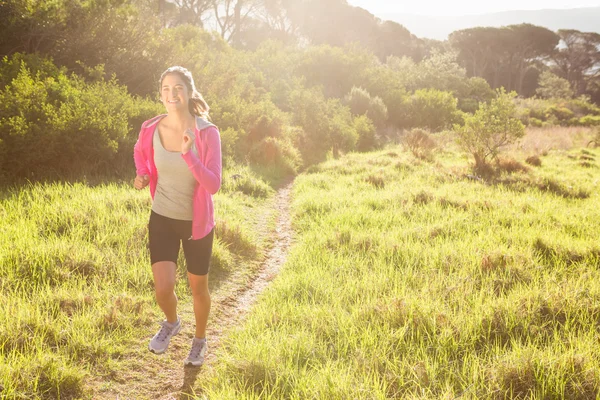 Fitte Frau joggt im Wald — Stockfoto