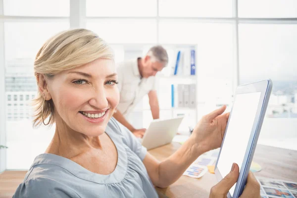 Mujer de negocios sonriente sosteniendo una tableta — Foto de Stock