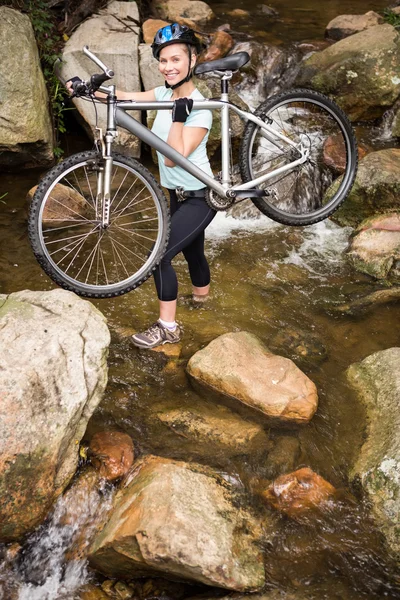 Gülümseyen kadın bisikletini kaldırma uygun — Stok fotoğraf