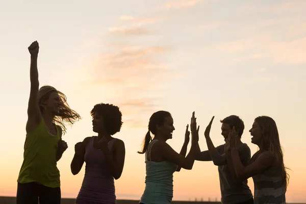 Femmes acclamant contre le coucher du soleil — Photo