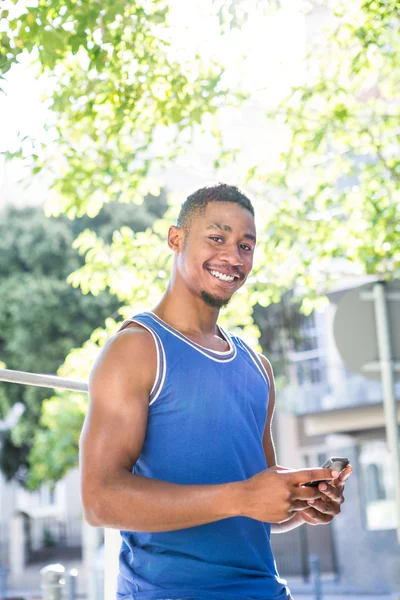 Atleta bonito usando seu telefone — Fotografia de Stock