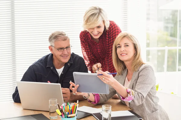 Glückliches Geschäftsteam, das über ein Tablet arbeitet — Stockfoto