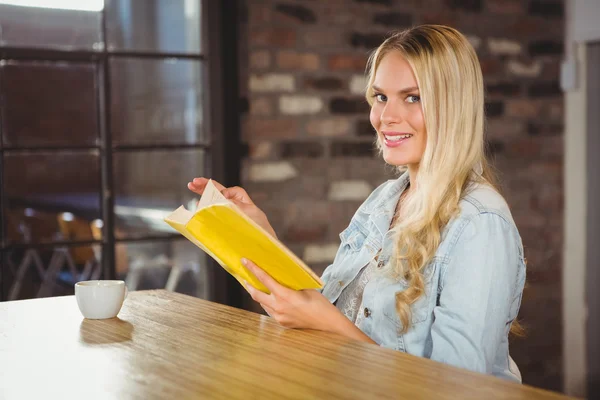 Smiling blonde turning the page — Zdjęcie stockowe