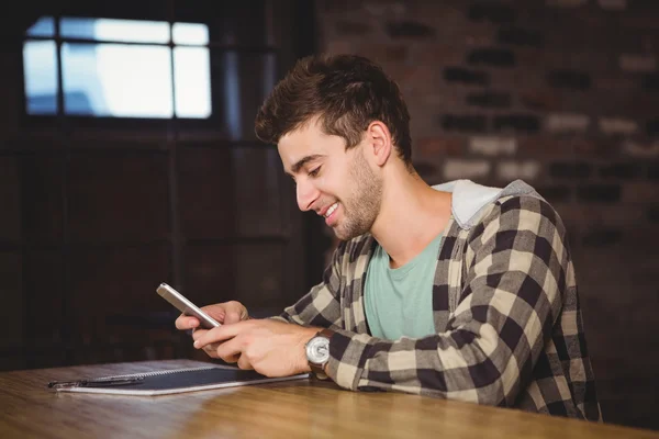 Leende hipster sitter och textning — Stockfoto