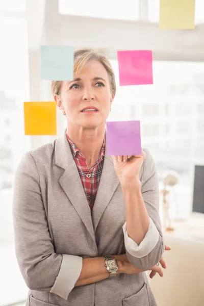 Businesswoman reading sticky notes — Stock Photo, Image